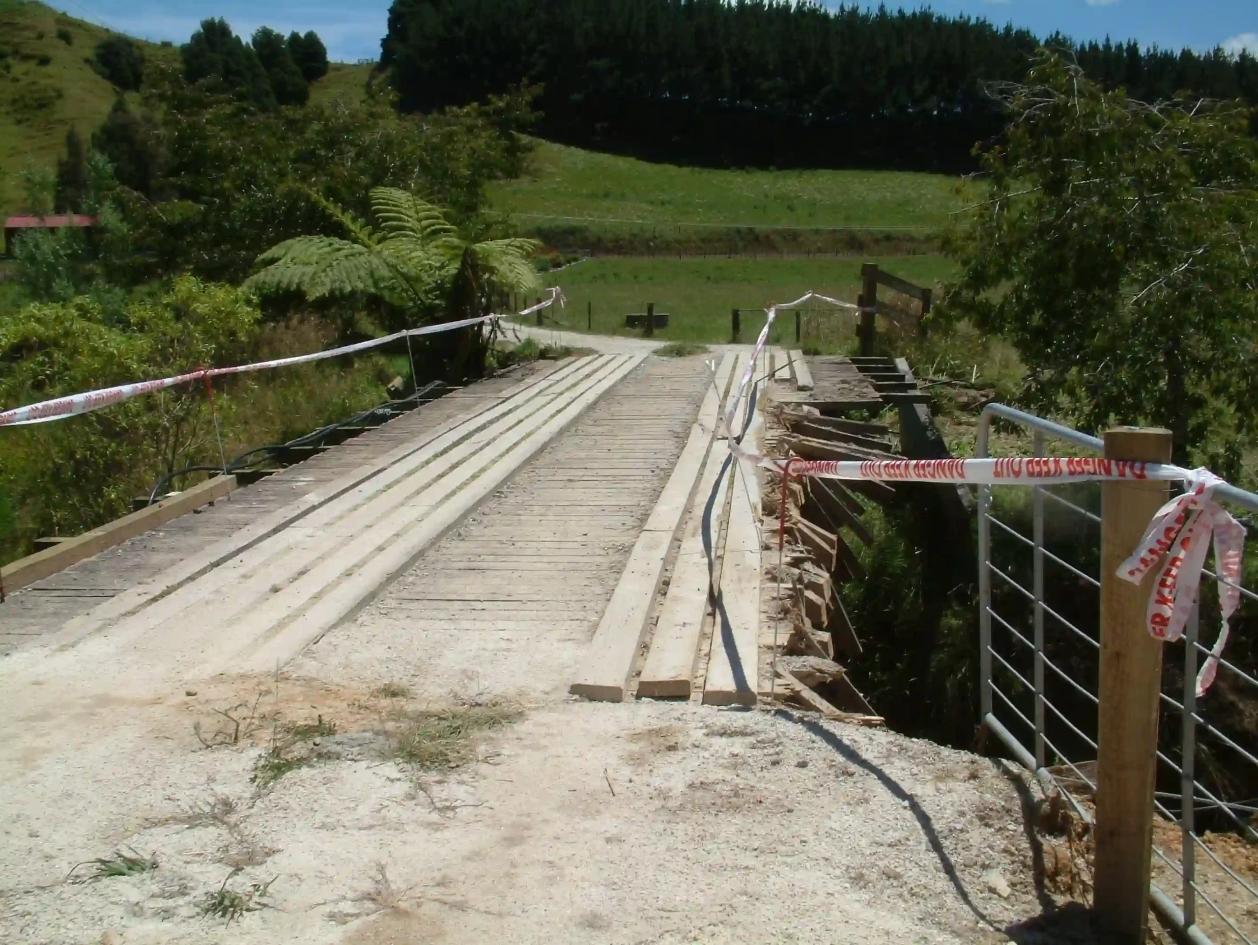 Weathered wooden bridge structural support post showing decay and damage